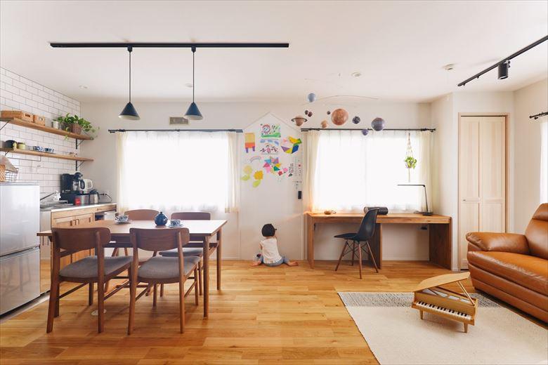 自由にお絵かきできるホワイトボードや天井から吊り下げた天体モービルは奥様のお気に入りを集めたスクラップブックから。日常にお子様の学びと遊びを取り入れたいという願いが込められている。窓際には書斎スペースとして使えるカウンターデスクを造作した
