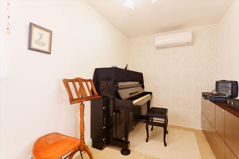 ピアノやバイオリンを演奏する音楽好きなご家族ために音楽室を実現。遮音シートや防音用の内窓を設置し、音漏れを軽減している。アクセントクロスでエレガントな雰囲気を演出