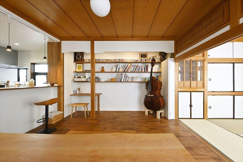リビングの一角にはデスクと書棚を造作。既存と同様の下がり壁をつくるなど、細かな点にも配慮。「しまうと弾かなくなるから」と楽器はあえて出しておけるようスペースを設けた。楽器が空間のアクセントにもなっている
