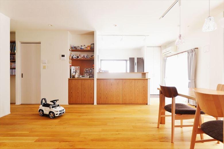 キッチンは家族を見守れる対面式に。収納を兼ねたキッチンカウンターや飾り棚付きの収納を造作。家族の写真やお気に入りの小物などを飾ることが出来る