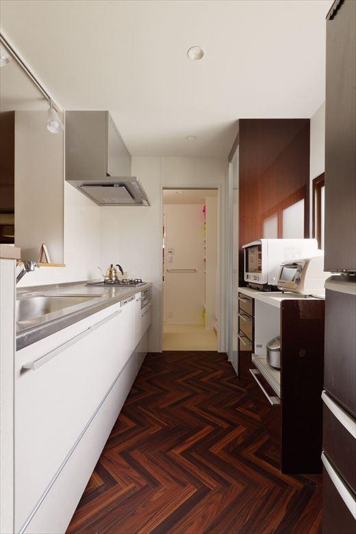 壁付けだったキッチンはオープンな対面式に。水廻りをキッチンの横に。キッチンと洗面室がダイレクトにつながるように工夫し毎日の家事もスムーズに。トイレは独立させた。冷蔵庫の横にパントリーとして使える収納も設置。床はヘリンボーンのフロアタイルでオシャレに。