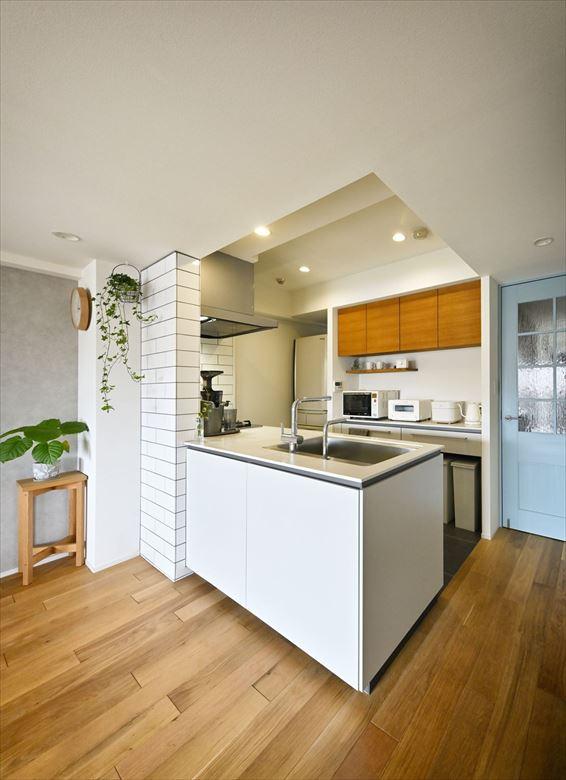 閉鎖的だったキッチンは、位置を変えずに壁を取り払ってフルオープンに。「主役になるようなデザイン性のあるキッチンに」という奥様の要望に応えている。背面収納も充実させて使い勝手も向上した