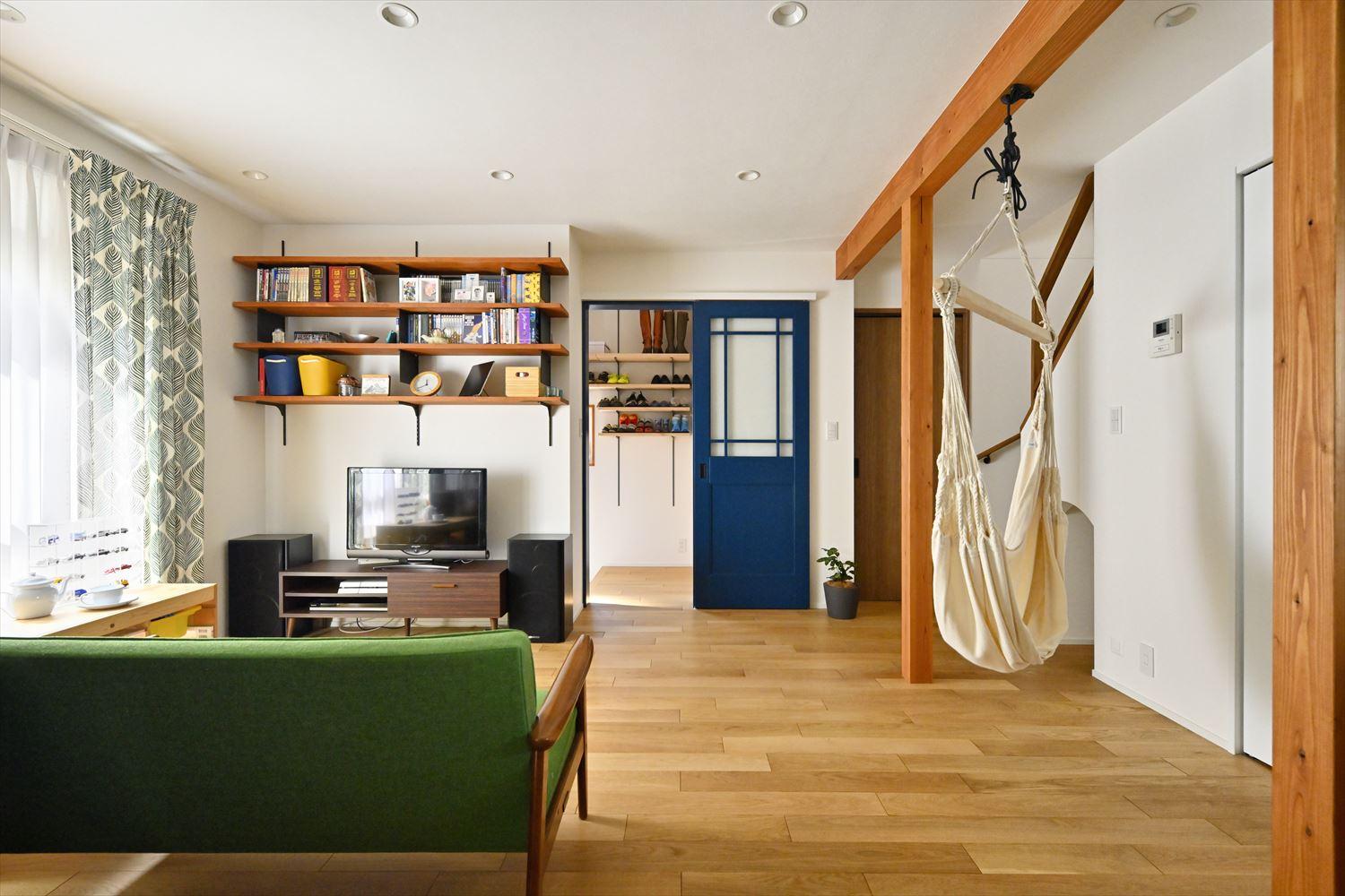 壁は白に、床はオークの無垢フローリングに張り替え、白×木目のナチュラルテイストに仕上げたLDK。テレビの背面には可動棚を設置。収納と飾り棚を兼ね備えている。庭に面した窓は前オーナーが取り付けたインナーサッシを再利用。