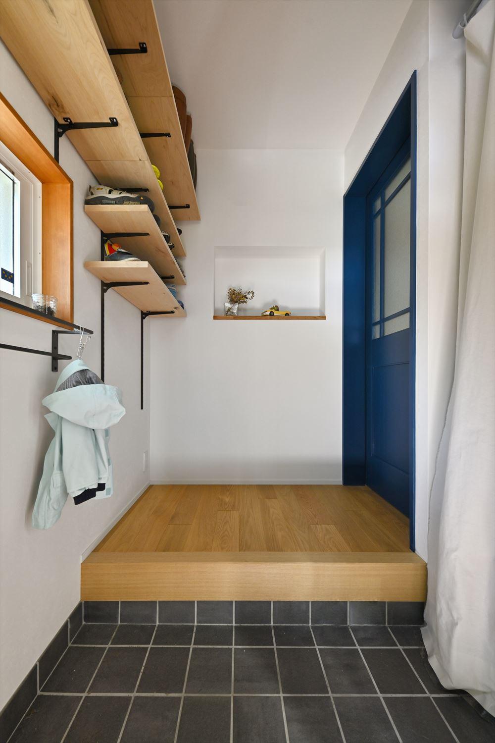 既存の靴収納は撤去してホールまでまたがるオープン棚を設置。リビング側と空間を取り合って土間収納を新設した。ホールは以前よりも少し広げ、正面につくったニッチで季節感を出したり、好きなアイテムを飾ったりできる