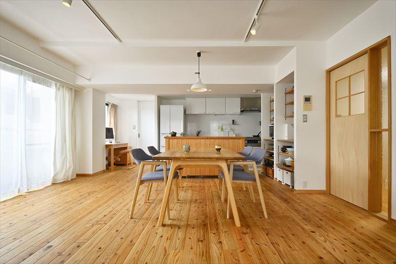 LDKの壁・天井は漆喰左官で仕上げた。窓際にハンガーパイプを設置して室内干しスペースを確保。「漆喰だと室内干しをしても空気がジメジメしないんです」とMさん。キッチンの左手に主寝室とつながる扉を新設して行き来をスムーズに。その手前にはワークスペースを