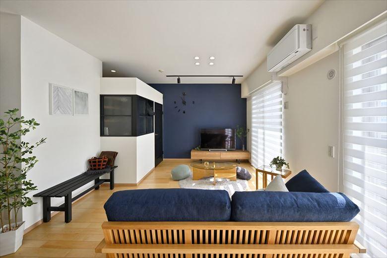 リビングは隣接していた居室を取り込んでゆったり広々と。リビングの一角には書斎スペースを設けた。テレビ背面のアクセントクロスはネイビーブルー。壁や天井の白や明るい木目と相性が良く、バランスの取れたお洒落な雰囲気に