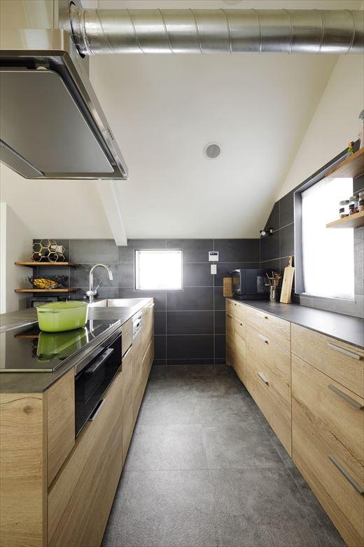 新しいキッチンはお気に入りのメーカーと決めていた。木目×グレーがシックなキッチンを採用。床は無垢床からお手入れしやすいフロアタイルに。壁には大判タイルをあしらい、高級感ある雰囲気に