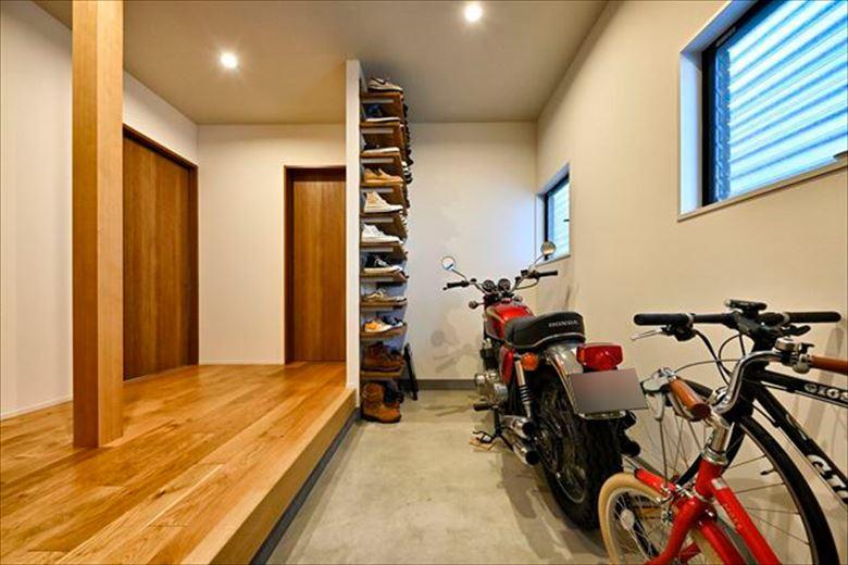 玄関には趣味のバイクを停めることができるスペースのある大きな土間を確保。靴収納はDIYで。ご自身で作る楽しみも満喫、さらにコストも抑えられ、一石二鳥？広々とした玄関ホールからは主寝室と子ども室、水廻りにつながる