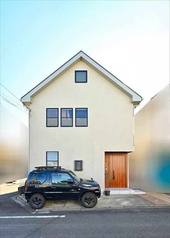 希望の立地条件＋三角屋根のシンプルなフォルムがイメージどおり、と購入を決められたそう。外壁はジョリパッド左官仕上げ。玄関廻りには檜を貼ってオイル塗装