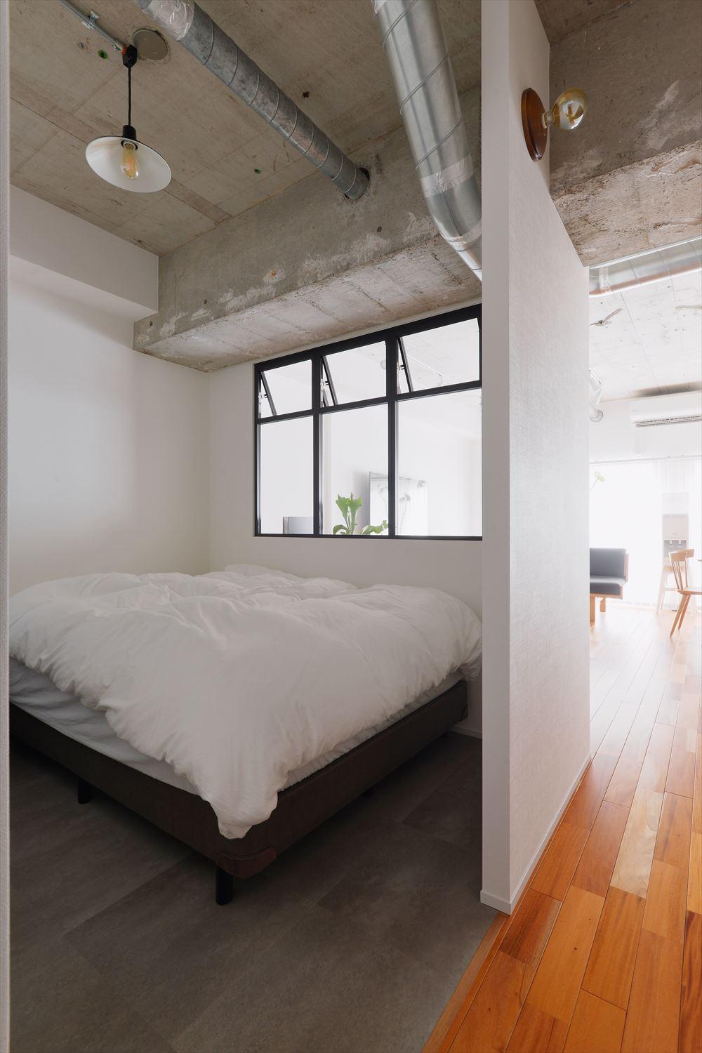 入口には扉を付けず、リビングとつながる寝室。リビングからの光が室内窓を通して部屋の奥まで届く