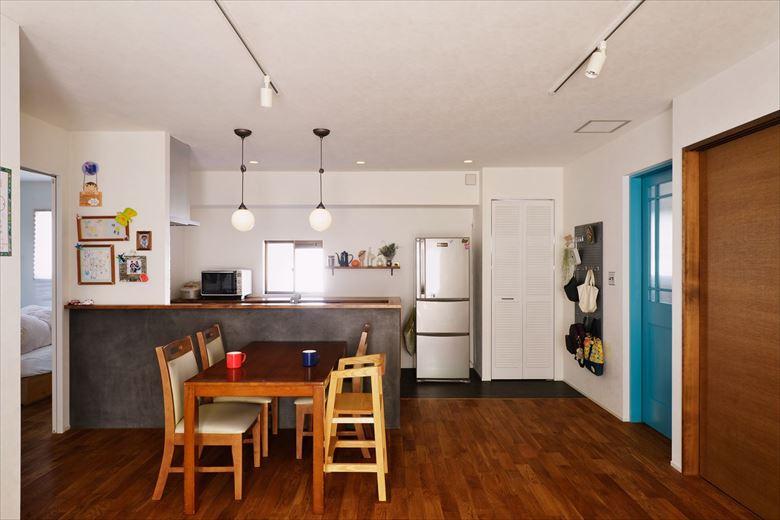 2階のミニキッチンは、ニキッチンは対面式のキッチンに変更。冷蔵庫横のパントリーは既存のトイレを移設して新たに設けたもの。ブルーのリビングドアが明るいアクセントになっている