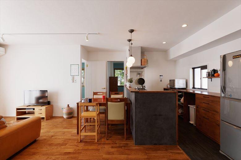 ナラの無垢フローリングを既存の床に上貼り。コストを抑えつつ心地良い空間に。キッチンカウンターの側面はモールテックスで仕上げ、木目との対比が楽しめる。広々としたLDKでお母様も一緒に過ごすことも