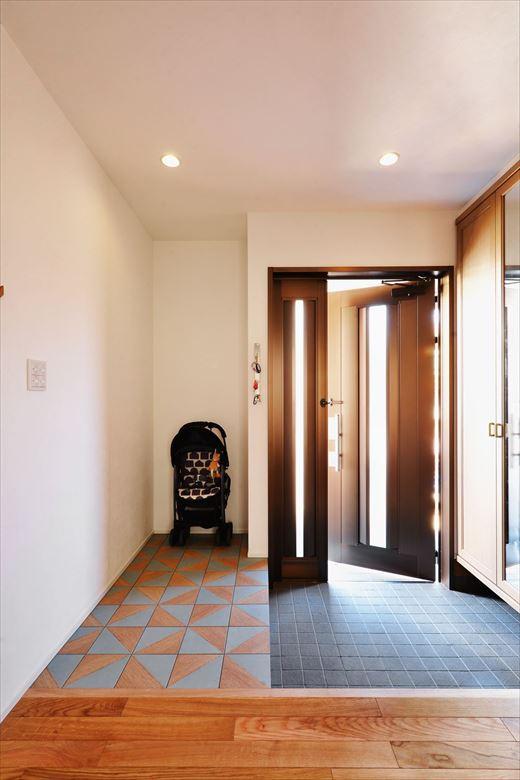 1階の玄関ホール。土間タイルや靴収納は既存を利用。隣接した収納スペースの壁を取り払い、広げた部分にはカラフルなタイルを貼った。ゆくゆくは子どもたちの自転車やアウトドア用品も置くことができる