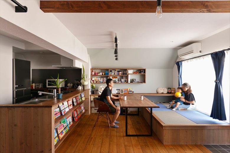 ブックシェルフを備えたキッチンの立ち上がりや飾り棚の色味も統一してアンティーク調に。ご夫妻が希望していた畳スペースは、ダイニングテーブルや壁側のカウンターデスクのベンチとしても活用できるよう小上がりにした