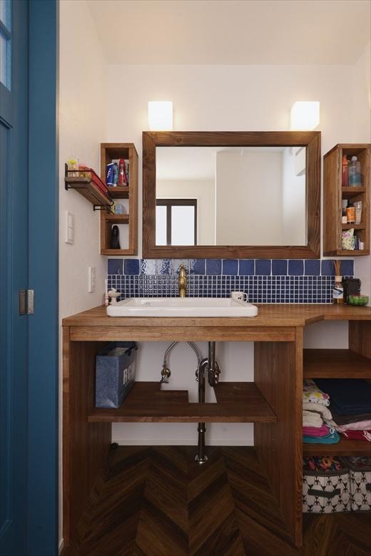 洗面は造作。立ち上がりにはレトロ調のタイルを貼った。木枠のミラーや両サイドの棚も、ご希望されていたアンティーク調にしたいというイメージにぴったりマッチしている