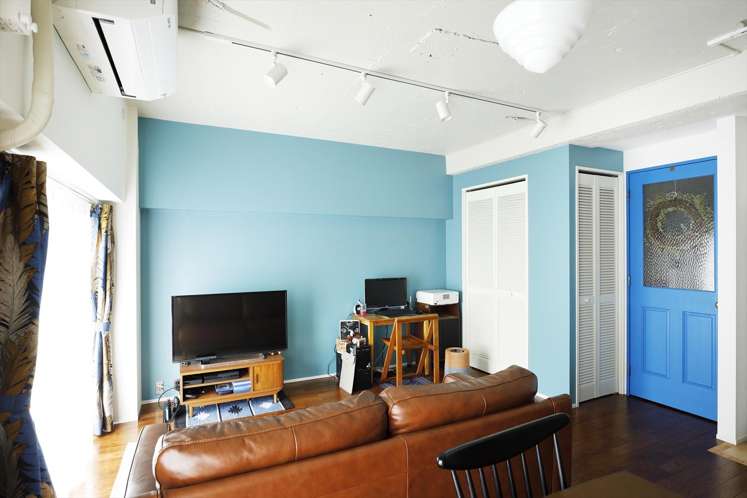 リビングとクロゼットの壁は明るい水色に。クロゼットは２面から使えるように内側を仕切って扉をつけ、より便利に。建具はアクセントになるブルーに塗装。