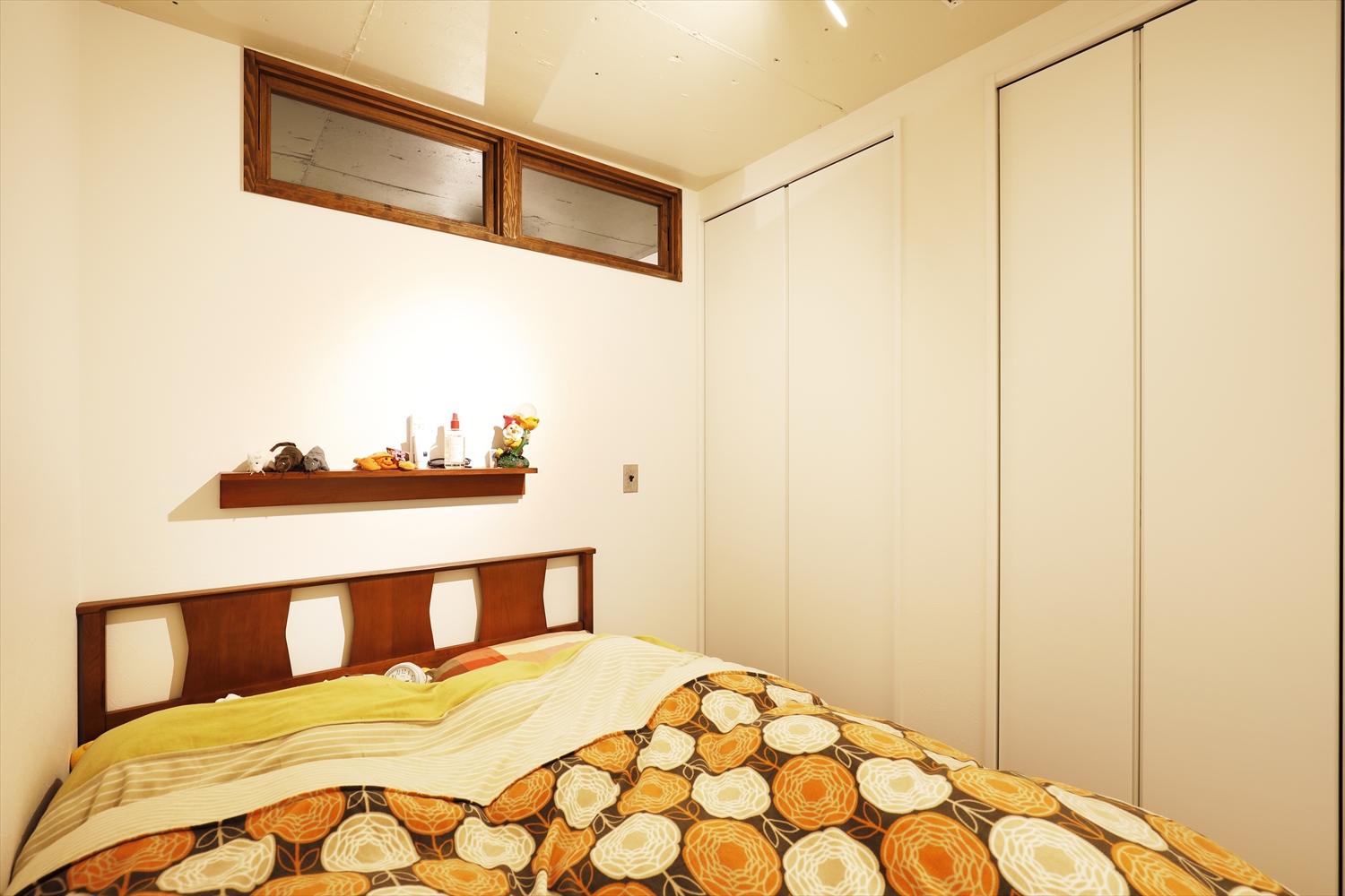 書斎とリビングの間に位置する主寝室。天井はリビングと同じように上げて塗装仕上げ。新しくクロゼットも造作し、収納スペースもたっぷり。窓がないため、書斎側の壁に室内窓を造作。共用廊下側からの光と風が、書斎を通して届く