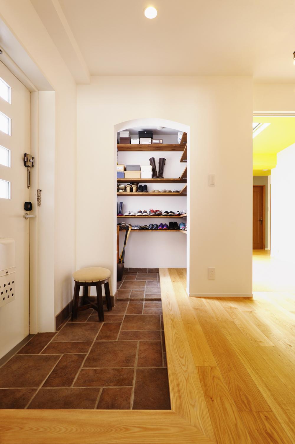 玄関はトイレだった部分まで土間を広げて、シュークロークを設けた。家族5人分の靴もすっきり収納できる。あえて扉は付けずにオープンにすることで、湿気を解消。お子さんたちのスポーツ用品などを出し入れしやすい。玄関ドアは内側を白く塗装し、明るいイメージに。