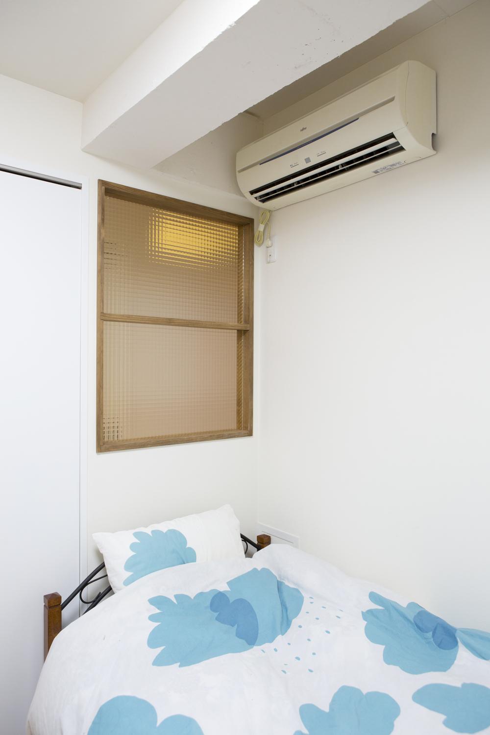 リビング隣の洋室。現在は子ども部屋として使っているが、将来は主寝室として使う予定。床は足ざわりのやわらかなコルクタイル。窓がないため、光が入るようリビング側の壁に室内窓を設けた