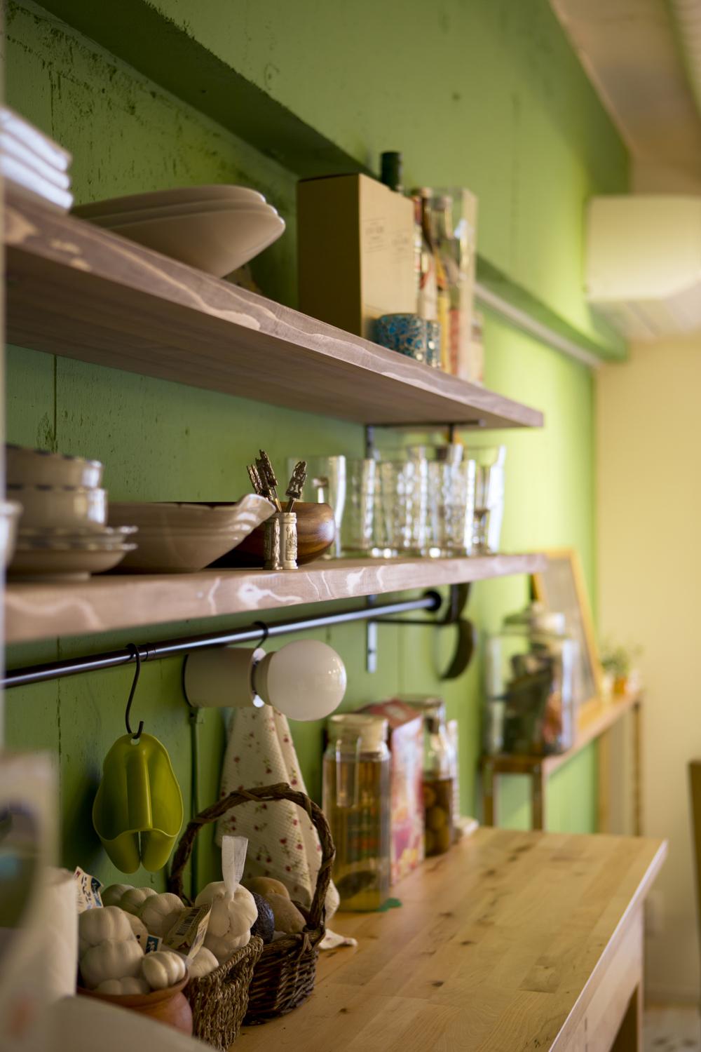 グリーンのアクセントウォールに造作したオープンな壁面収納。雰囲気たっぷりで収納も楽しくできそう。
