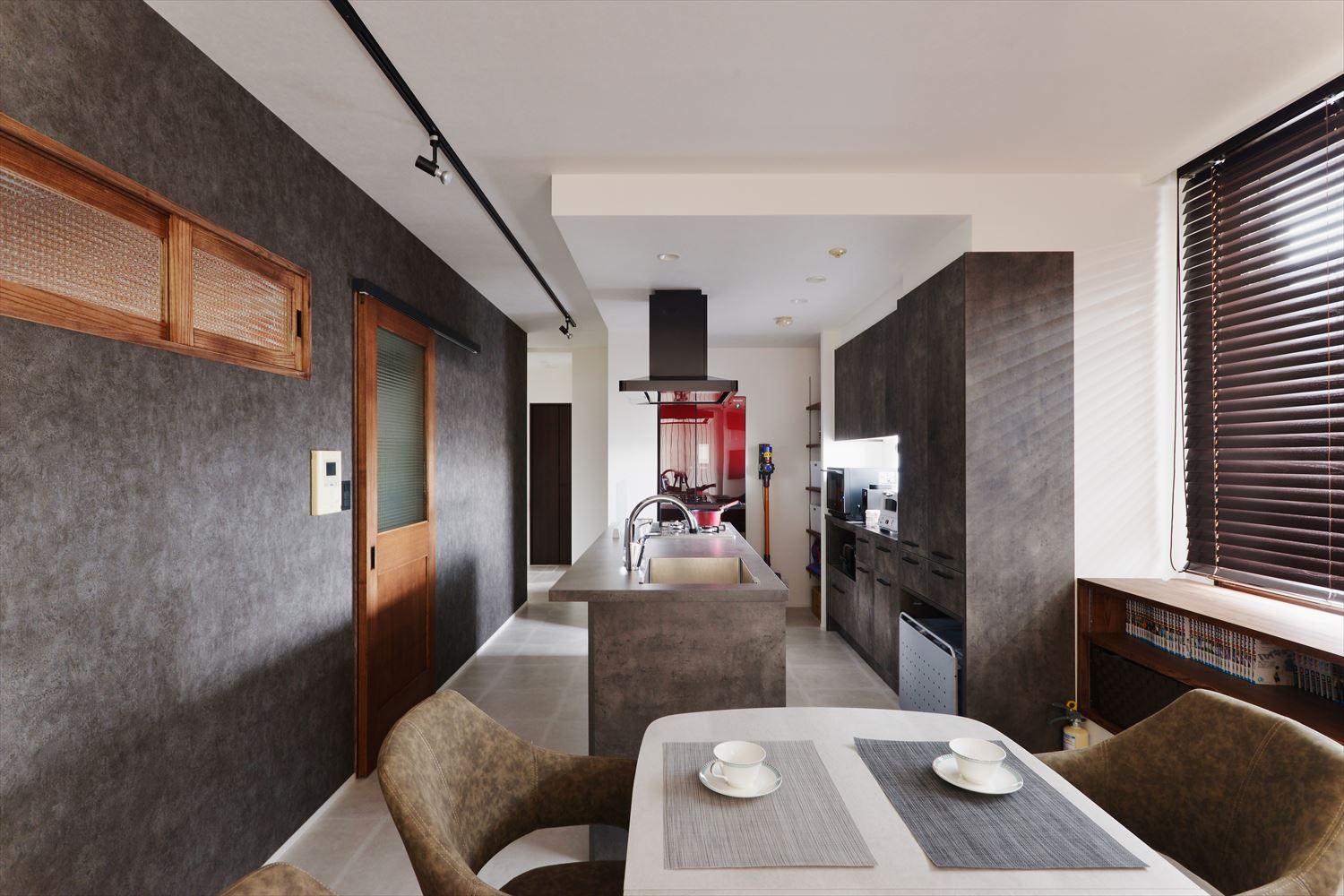 キッチンからダイニングへの配膳も横移動だけなのでスムーズ。
キッチン奥には冷蔵庫も置けるパントリーを設けた
キッチン正面の扉を出ると玄関へ。手前の室内窓は旦那さんの個室とつながっている