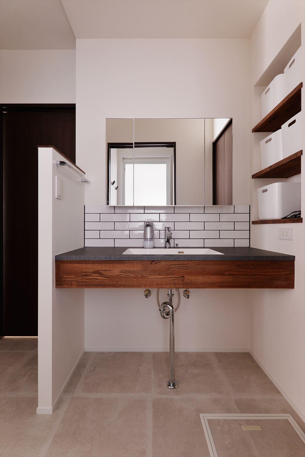 シンプルな洗面だが、横のニッチ収納や鏡裏の収納ですっきりをキープ。