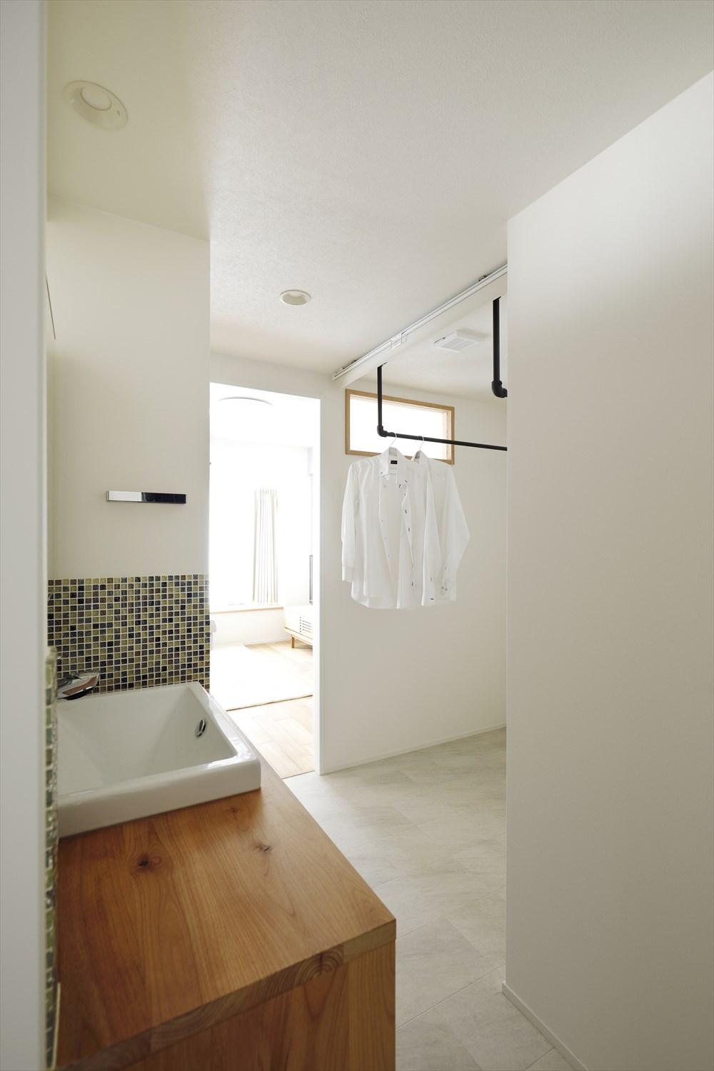 洗面脱衣所には部屋干しスペースを併設。
洗面横の壁の向こうは洗濯機置き場。洗濯のあとは振り向くだけで洗濯ものが干せる！
