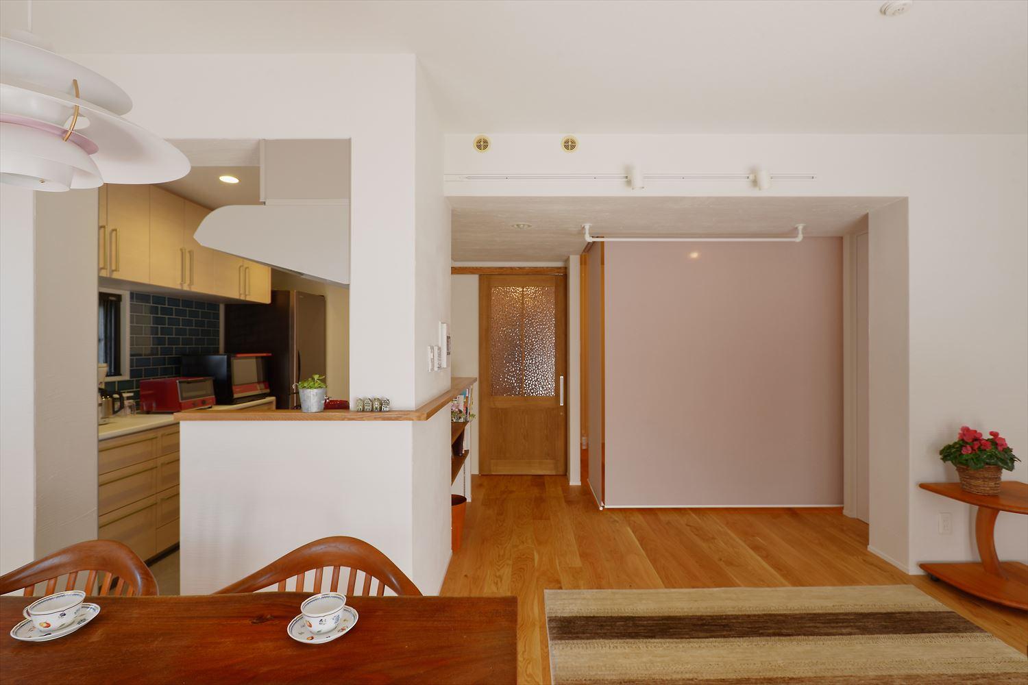 寝室部分はロールカーテンで仕切れるようになっていて、日中はロールスクリーンを上げてリビングの一部として。就寝時にはロールスクリーンを降ろして、コンパクトな寝室に。就寝時と日中で使い分けができる。