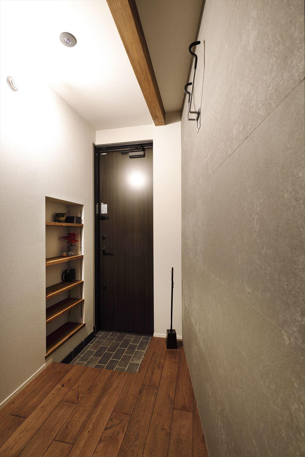 玄関は斜めに壁を設置して広さを感じられるように。壁には、自転車を掛けて収納できる。