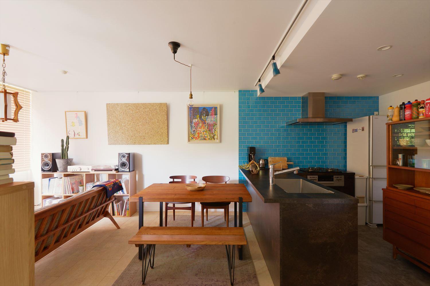 閉塞感のあったキッチンの壁は撤去して、一体感のあるLDKに。
キッチン壁のターコイズブルーが空間のアクセントになっています