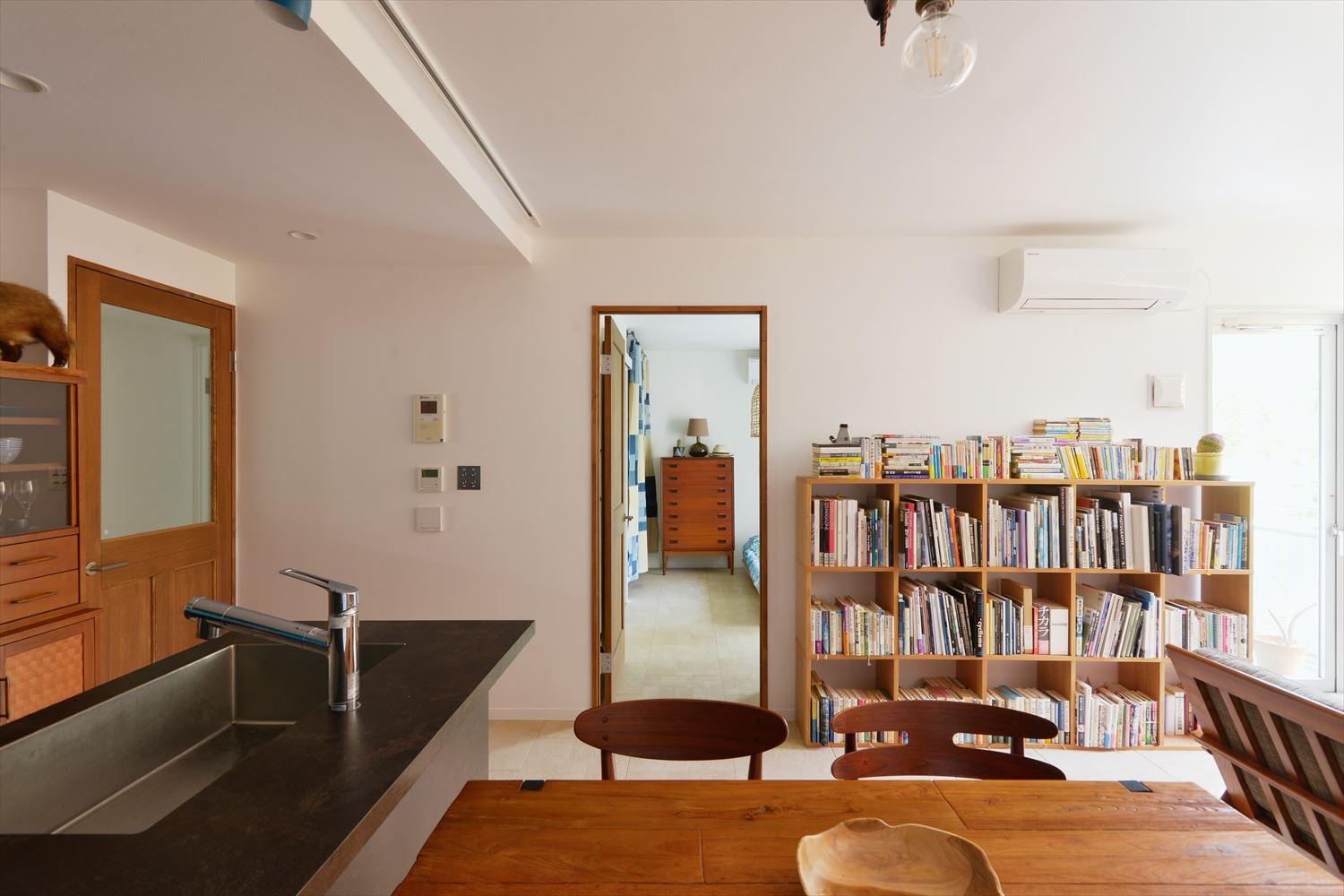 寝室につながる扉の脇に大量の本が収納できる書棚を設置