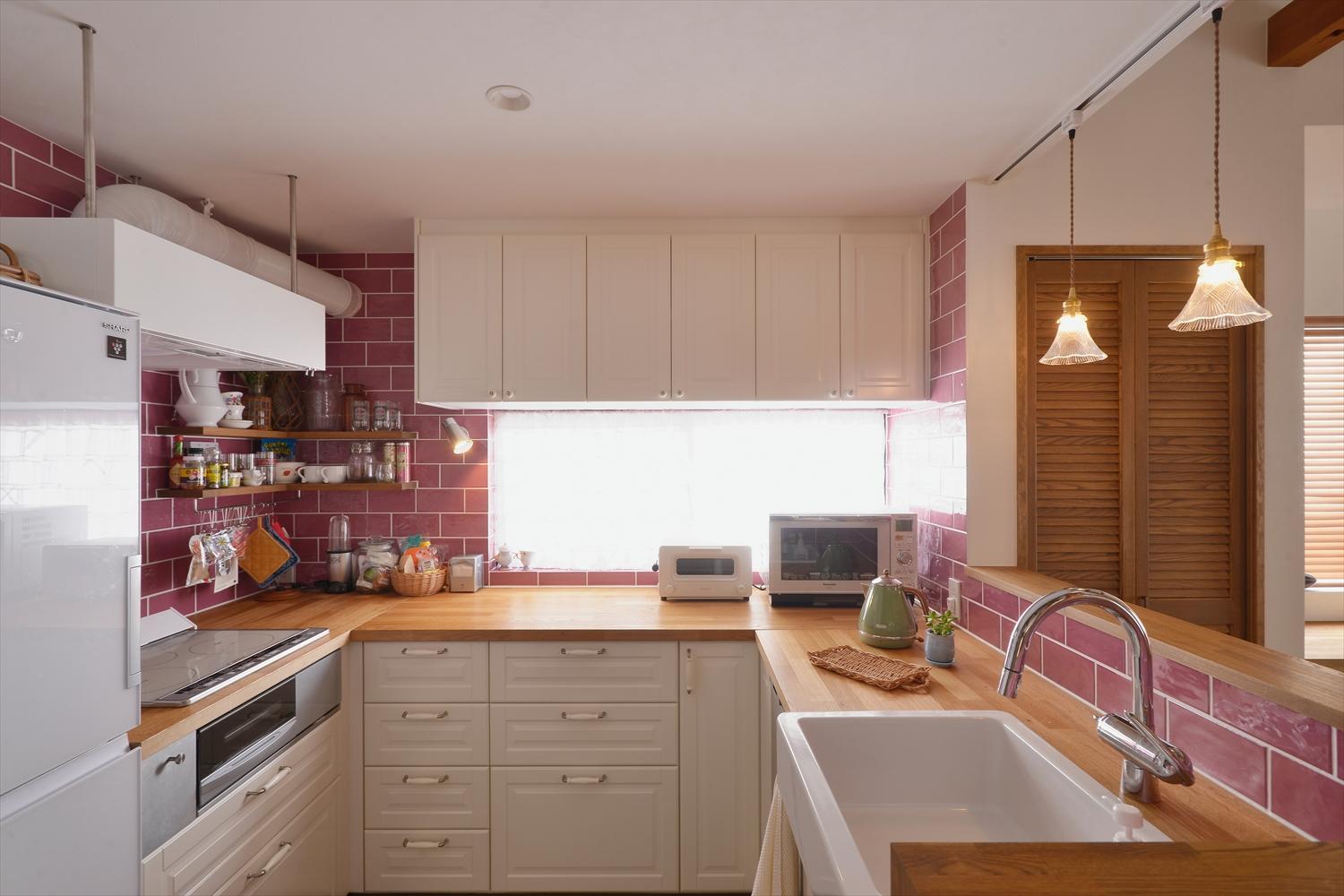 壁に囲われ独立していたキッチンはコの字型のオープンキッチンに。おくさまがじっくりと吟味して選ばれたピンクのタイルで華やかな空間になった