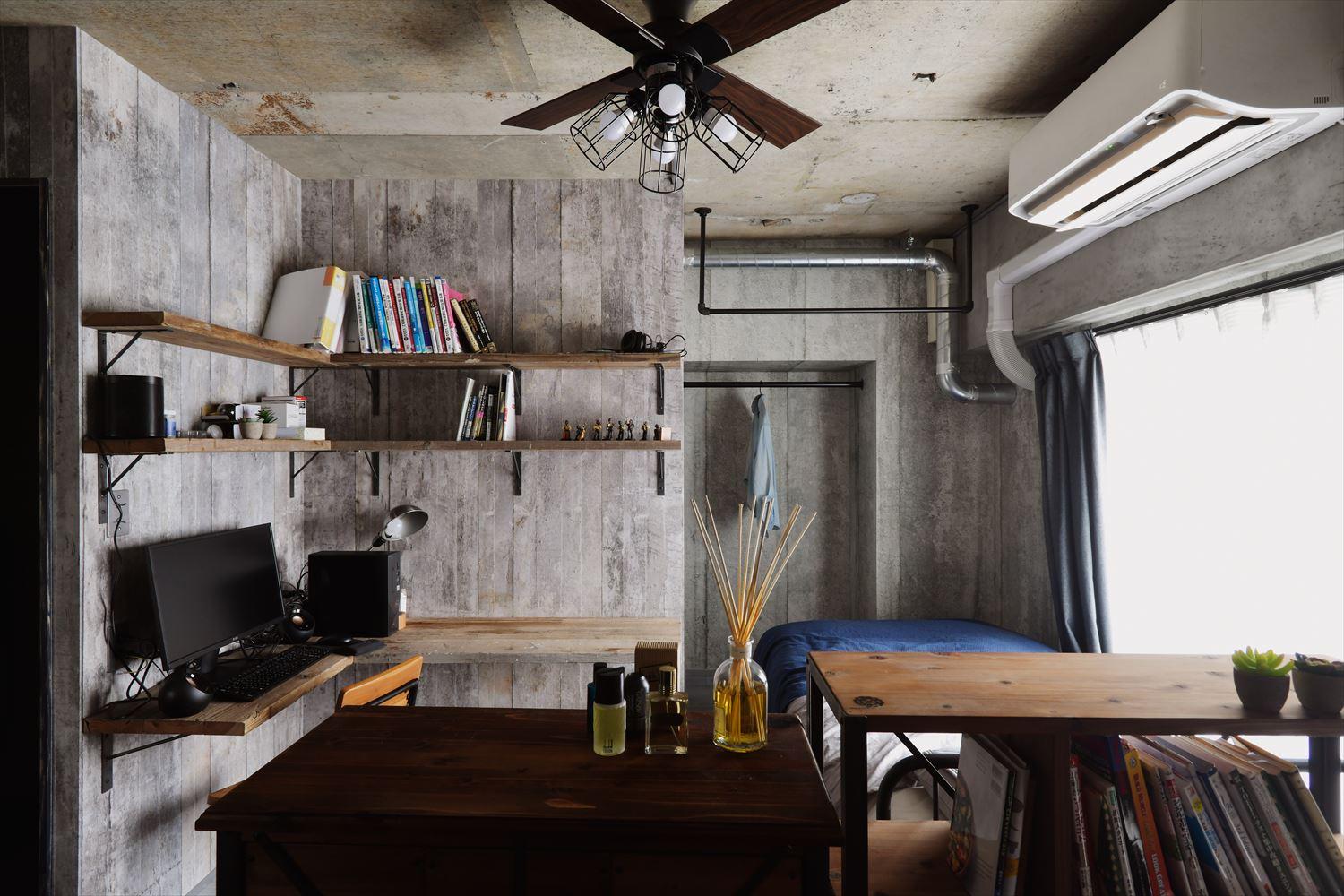 水廻りの右側は寝室スペース。クロゼットは扉無しのオープンで使い勝手よく。
壁に沿ってご希望だったL字のカウンターと書棚を造り書斎コーナーに。リビングとの間は収納家具を置いて緩やかに住み分けている