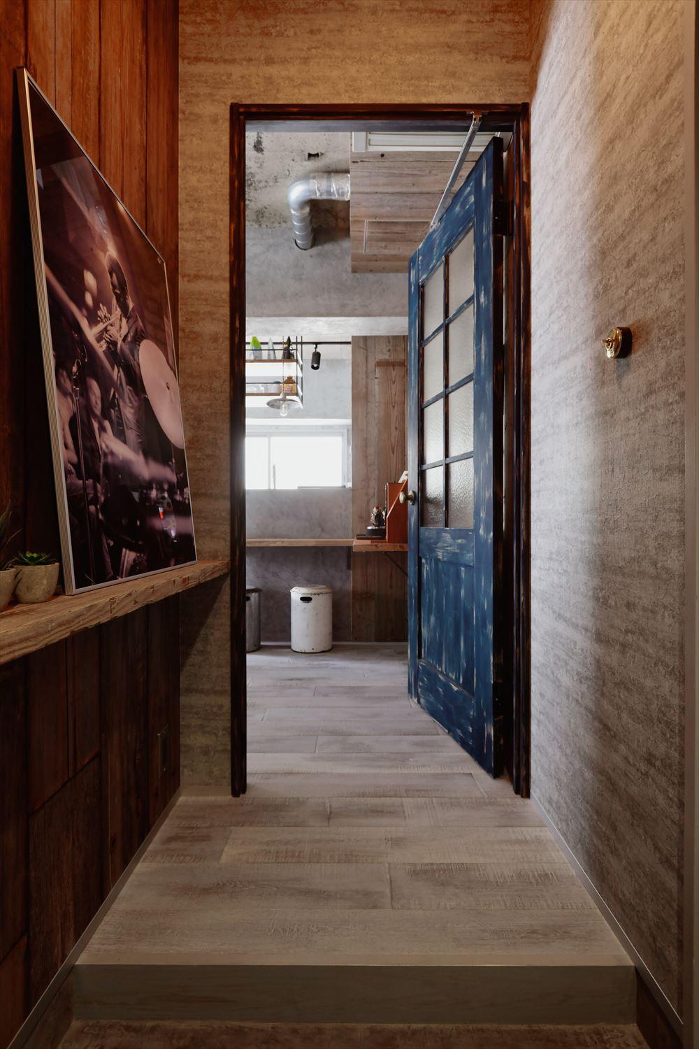 洗濯室を拡張した分、玄関ホールが広く取れ、斜めだった框もまっすぐに。
新たに設置したリビングドアは好きなように塗装できるもので、現場で雰囲気を見ながら「かすれた感じ」に仕上げた