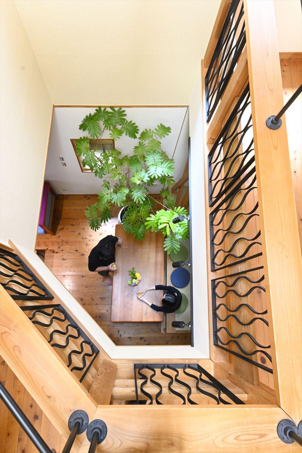 2階の吹き抜けから1階を見下ろす。既存のままでは落ちそうで不安だったので、手すりに特注のアイアンパネルをはめ込み、上部にはコの字型のアイアンを取り付けて安全に。テーブルの脚やライティングレールと同じ色で、空間が引き締まります。