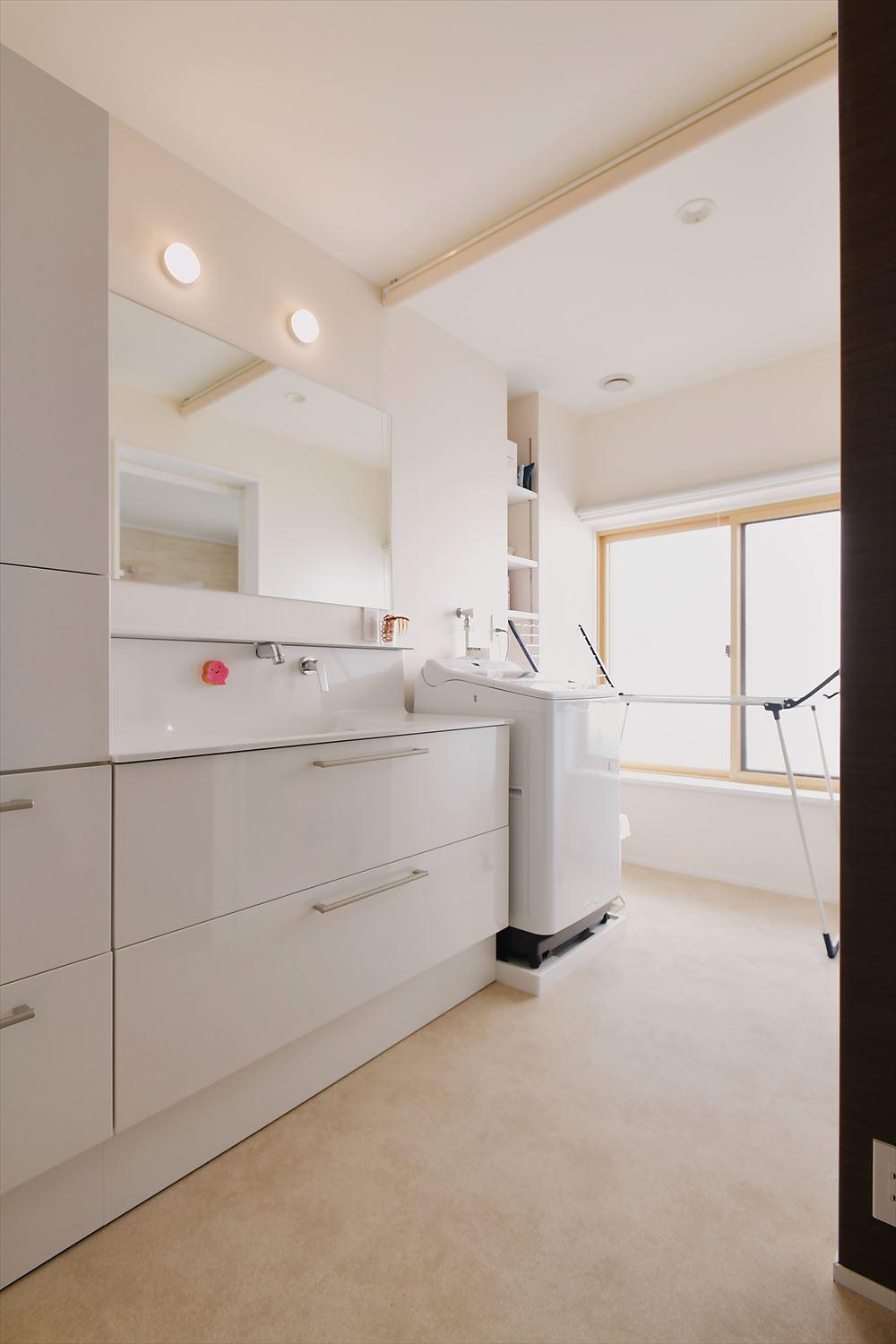 洗面室はスペースを拡大。洗面台の奥には室内干しスペースも確保した。洗面台と洗濯機の間はロールスクリーンを設置し、来客時などは下げて目隠しできる