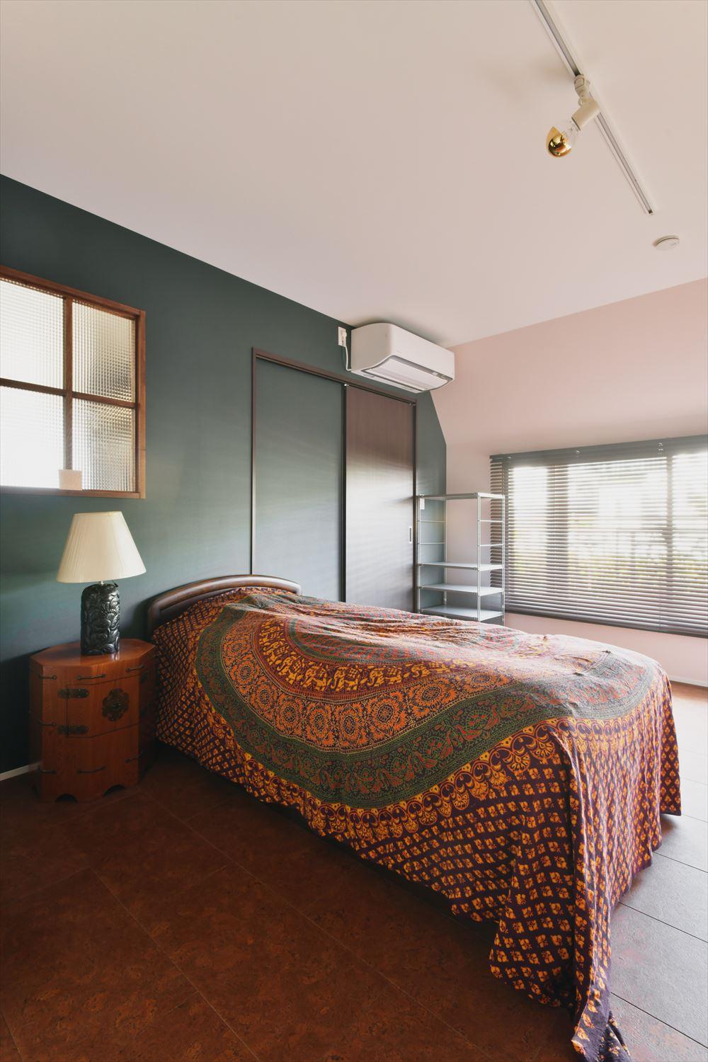 コルクタイルを敷いた寝室。足ざわりのいいコルクタイルで季節を問わず起きて最初の一歩が心地よい。室内窓の向こうはウォークスルークローゼット