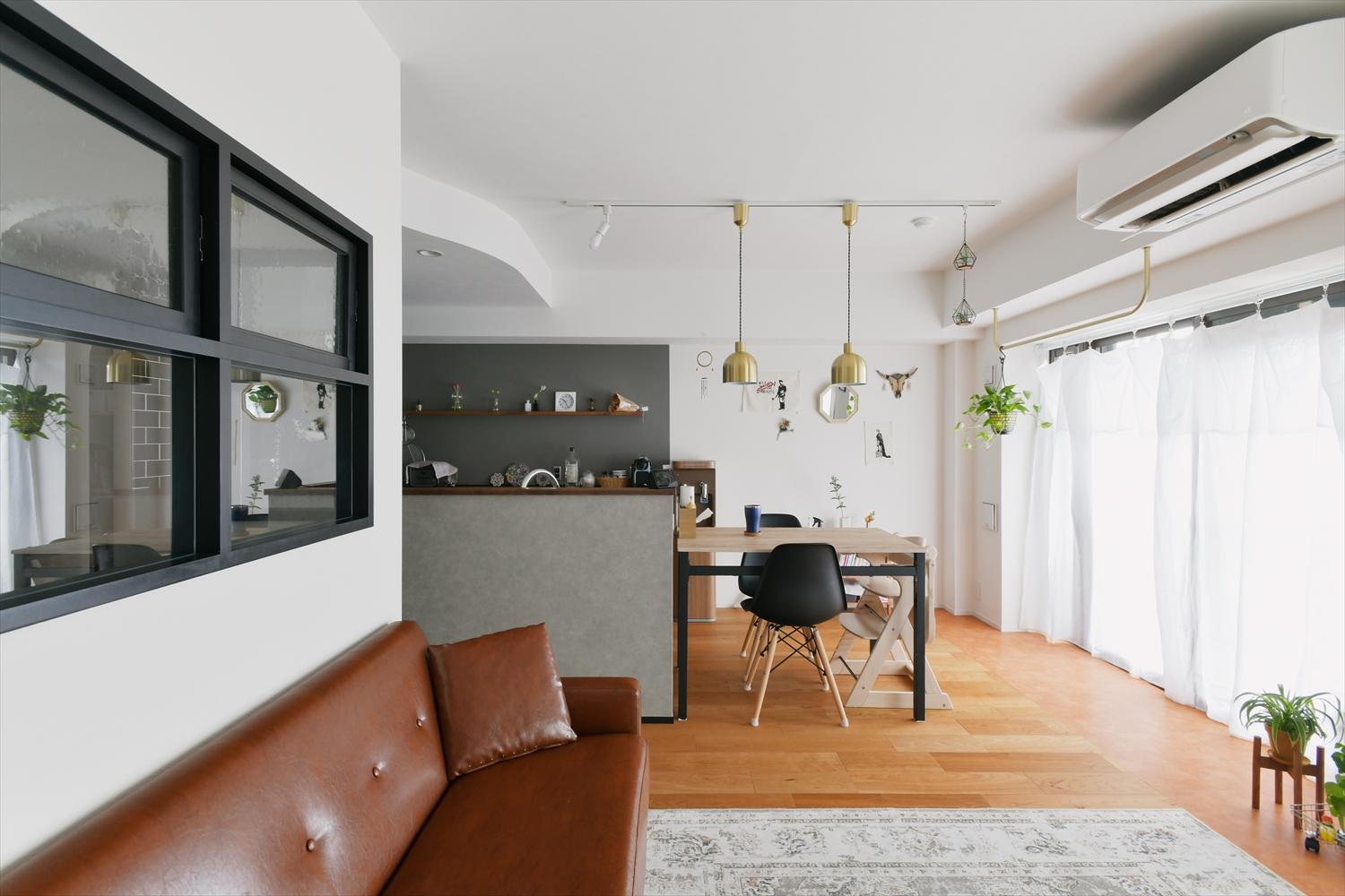 床は深みのある色合いが特徴的なブラックチェリーのフローリング。
ブラック系でまとめたキッチン周りや室内窓の枠の色、照明の真鍮でヴィンテージ感のある空間に。
天井や開口にアールを入れて柔らかさをプラス