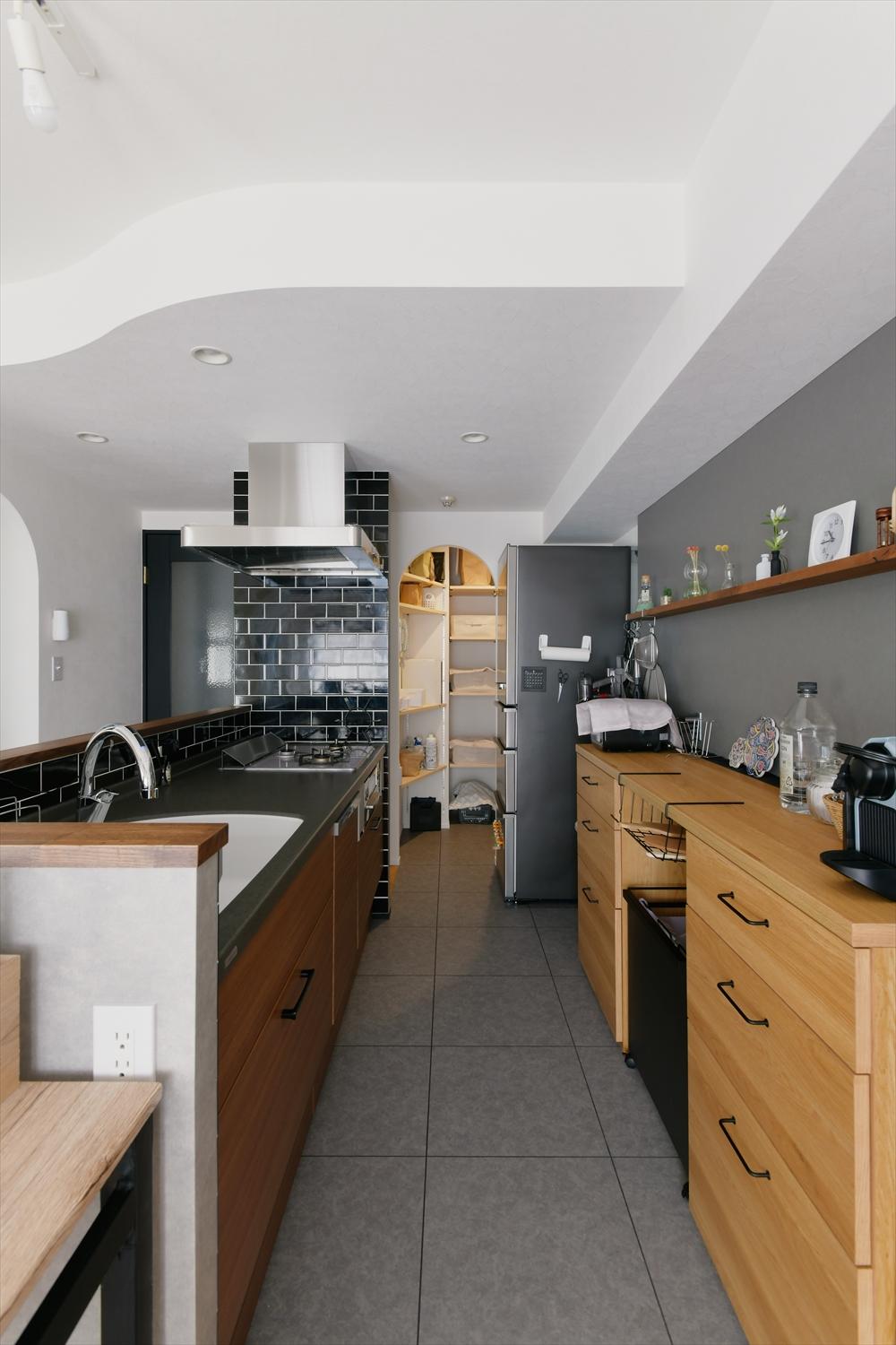 壁付けだったキッチンをアイランドタイプに。リビングやスタディスペースにいる家族の様子が見える。
キッチン奥にはパントリーももうけた。パントリー内は３面に可動棚をつけてたっぷり収納力を確保