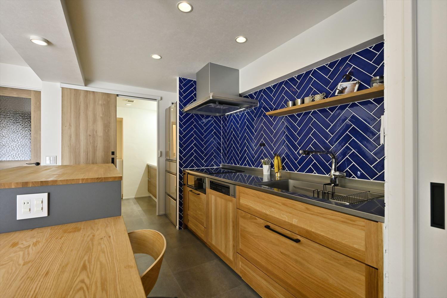 キッチンから直接洗面脱衣所にアクセスできる動線を作った。朝の準備や家事がスムーズになる。キッチン壁のタイルは憧れのヘリンボーン貼りに。