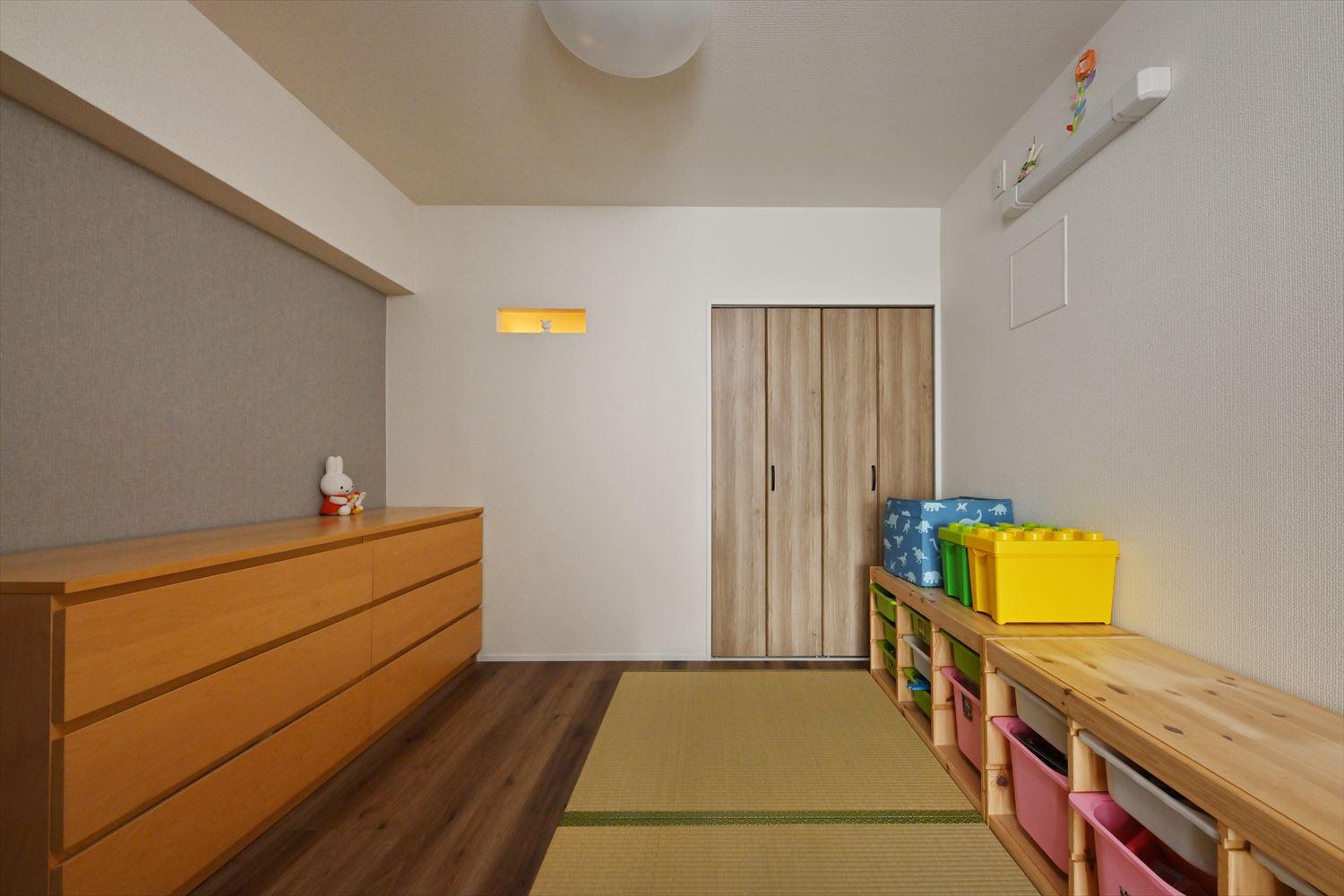 リビング横のキッズスペース。奥の明かりはウォークインクローゼットから届く灯り。ウォークインクローゼットに隣接する部屋に小窓を設け、ウォークインクローゼットの中の通気を確保した