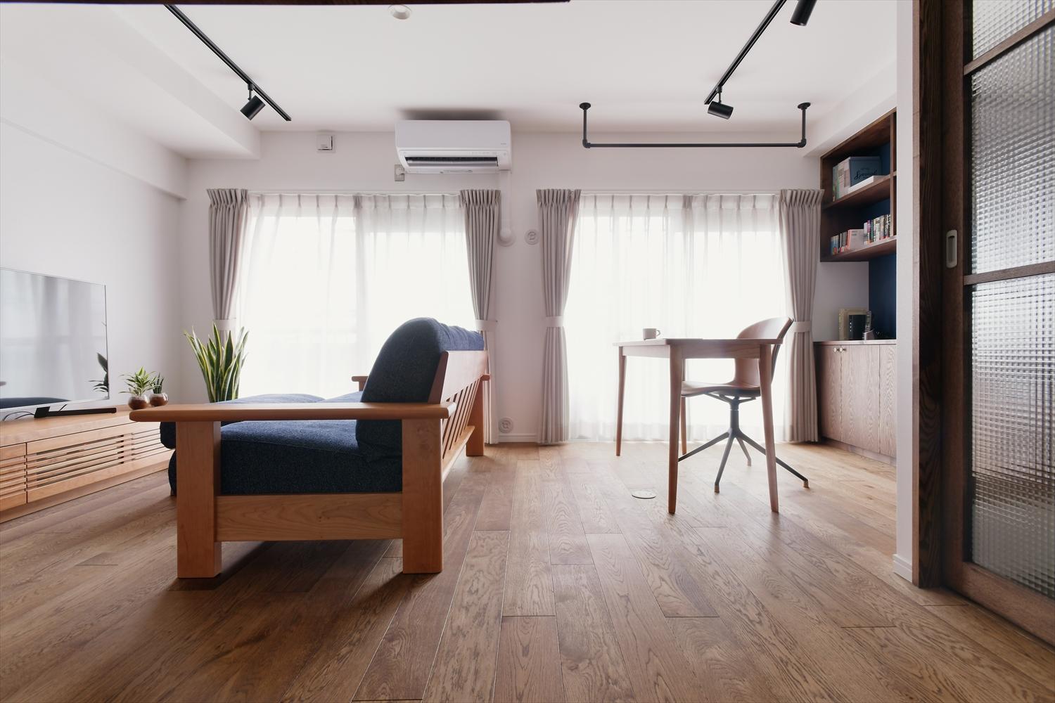 玄関の仕切り戸を開けると、視線の先に光に満ちた空間が広がる。リビング右手は書斎コーナー。デスク背面は壁面いっぱいに書棚を造作した。