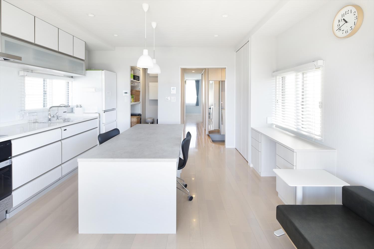 2部屋をつなげて広くなったLDK。キッチン背面の作業カウンターと窓際のデスクは、在宅ワークの多いご夫妻の大切なお仕事スペースに。
白をメインとした内装で明るい空間に。