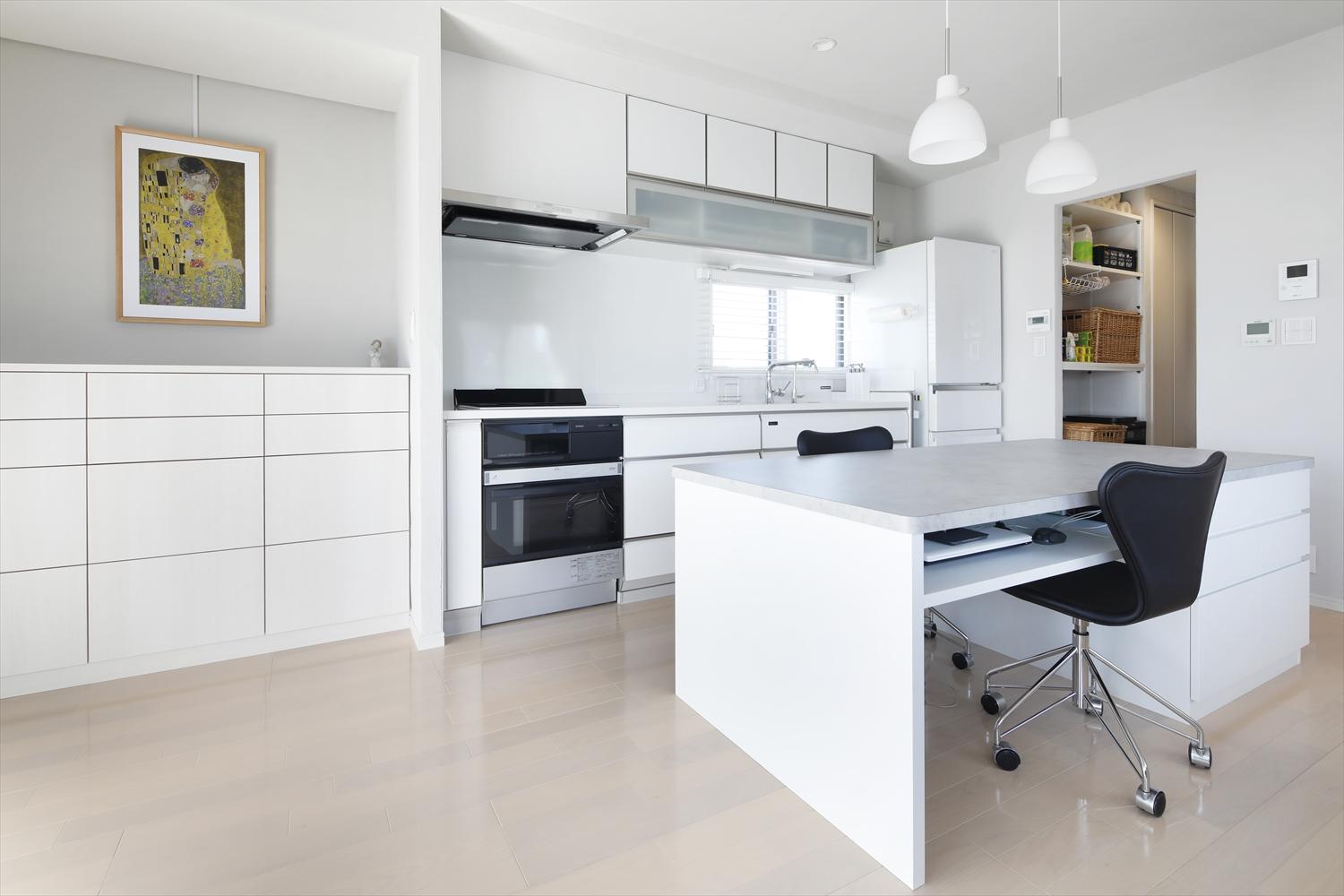 キッチン奥にはパントリーを造作。溢れがちな食材やキッチン家電もたっぷり収納できるので、キッチン周りはスッキリ。作業カウンターは料理の準備、ダイニングデスク、ワークスペースとマルチに活用できる。