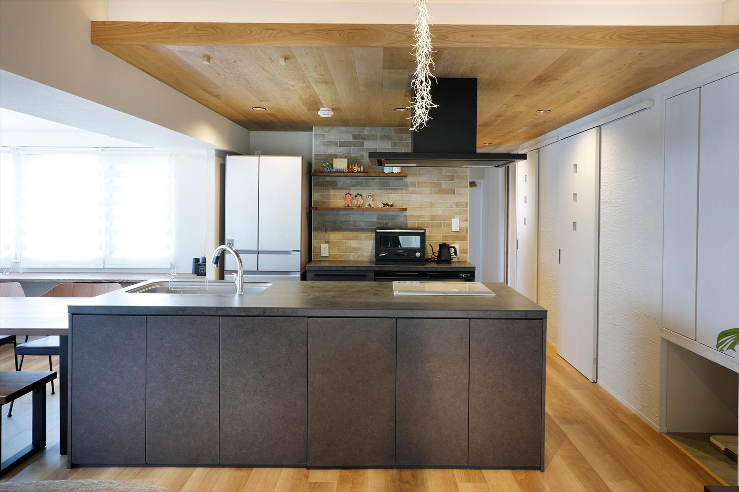 まっすぐ水廻りにアクセスできるキッチン。廊下からキッチンまでつながる木目の折り下げ天井の間接照明をつけると、LDK全体がやさしい雰囲気に。