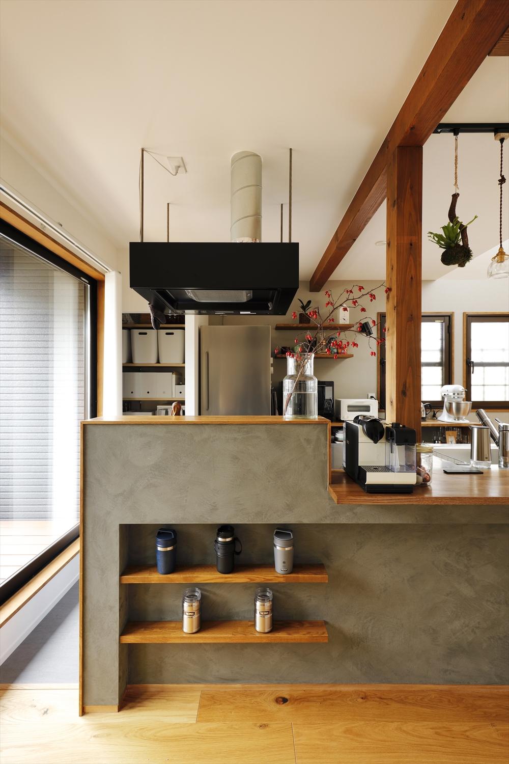 モルタル調に仕上げたこだわりのキッチンカウンター。キッチン背面には家電収納・パントリー造作し、収納もしっかり確保。