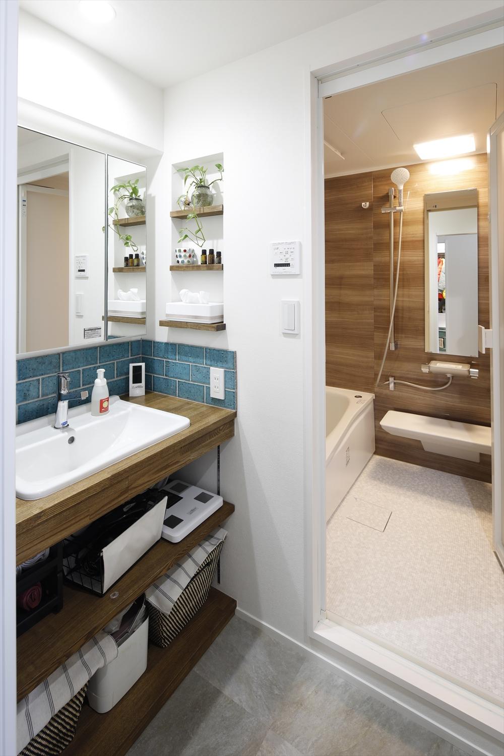 造作の洗面台。立ち上がりに貼ったグリーンのタイルがアクセントになっている。