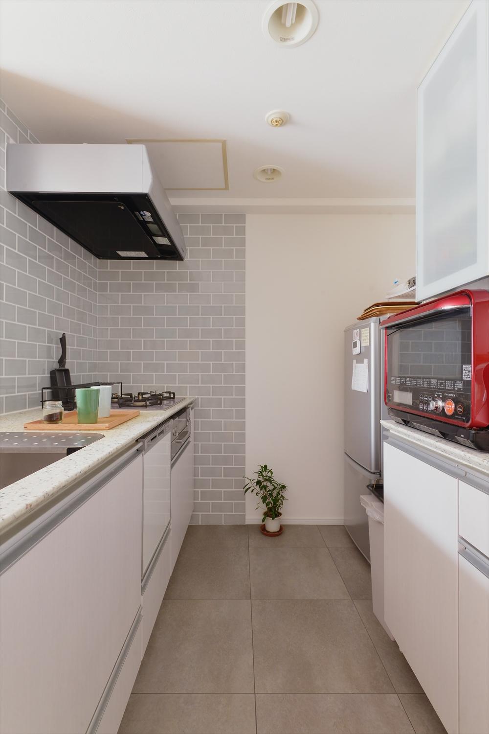 きちんとお手入れされていて、そのまま使える状態だったキッチンと背面収納はそのまま再利用。床はフロアタイルに交換。コンロ側の壁にはこだわりのタイルを。これだけで雰囲気が一新。ナチュラルで明るいキッチンになった。