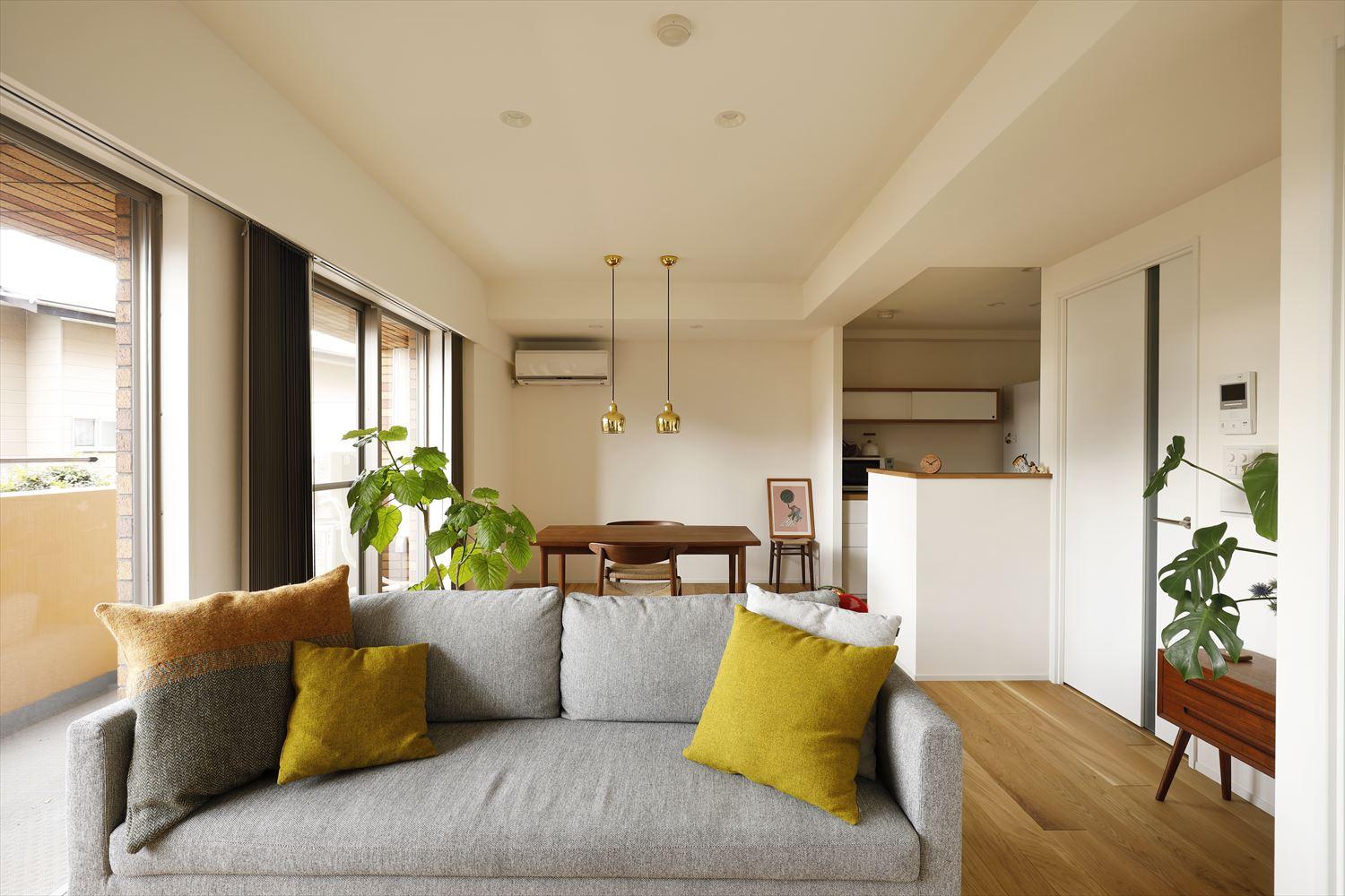 白い壁・天井にオークフローリングや木製の家具が馴染むシンプルな内装を目指した。
グリーンやクッションの黄色がアクセントになっている