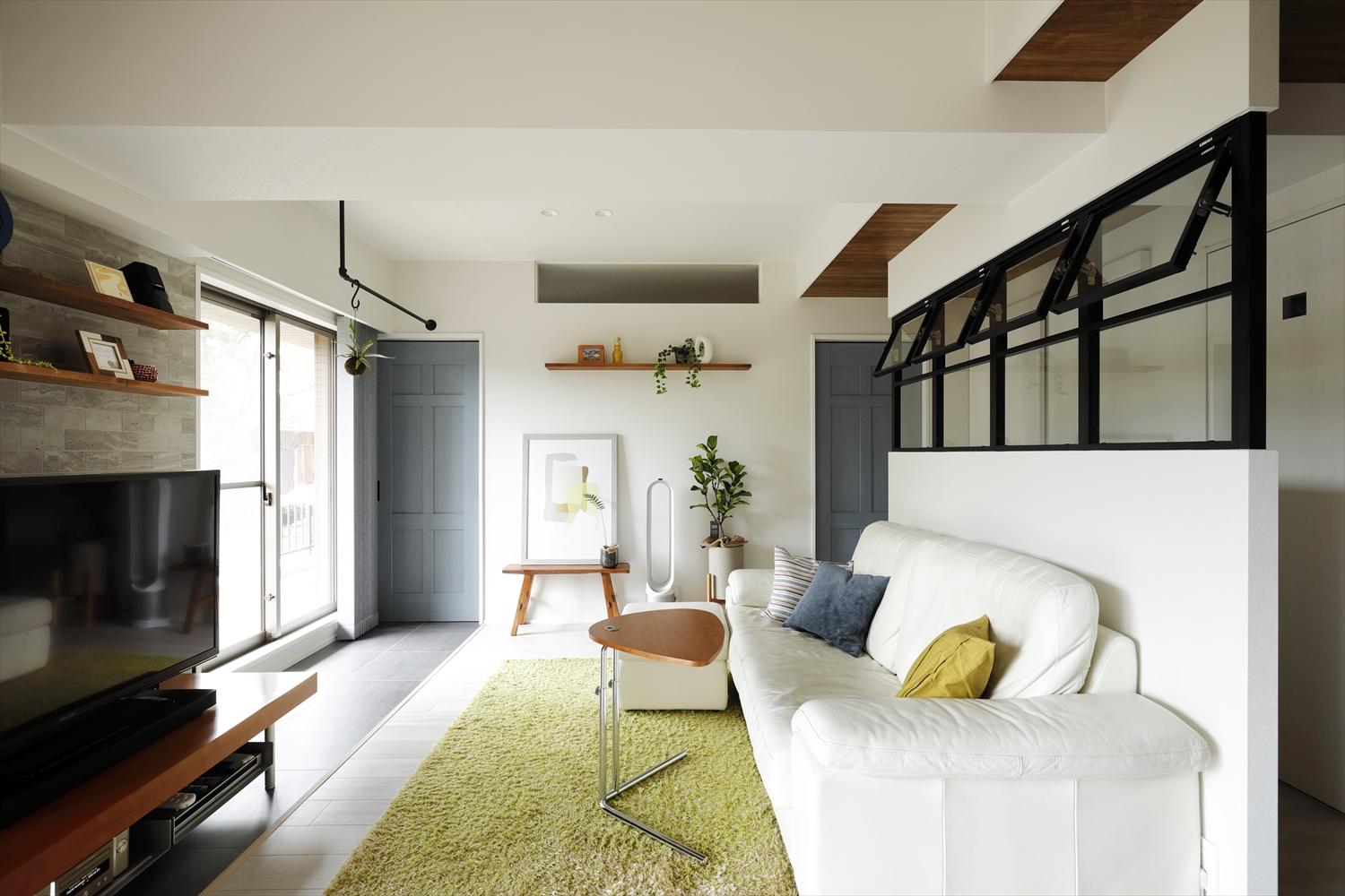 LDKの奥にあるブルーグレーの扉から寝室＋書斎のプライベート空間へ。テラスをイメージした窓際のタイル敷きはWIC～寝室まで伸ばし、素材のつながりもデザインのポイントに